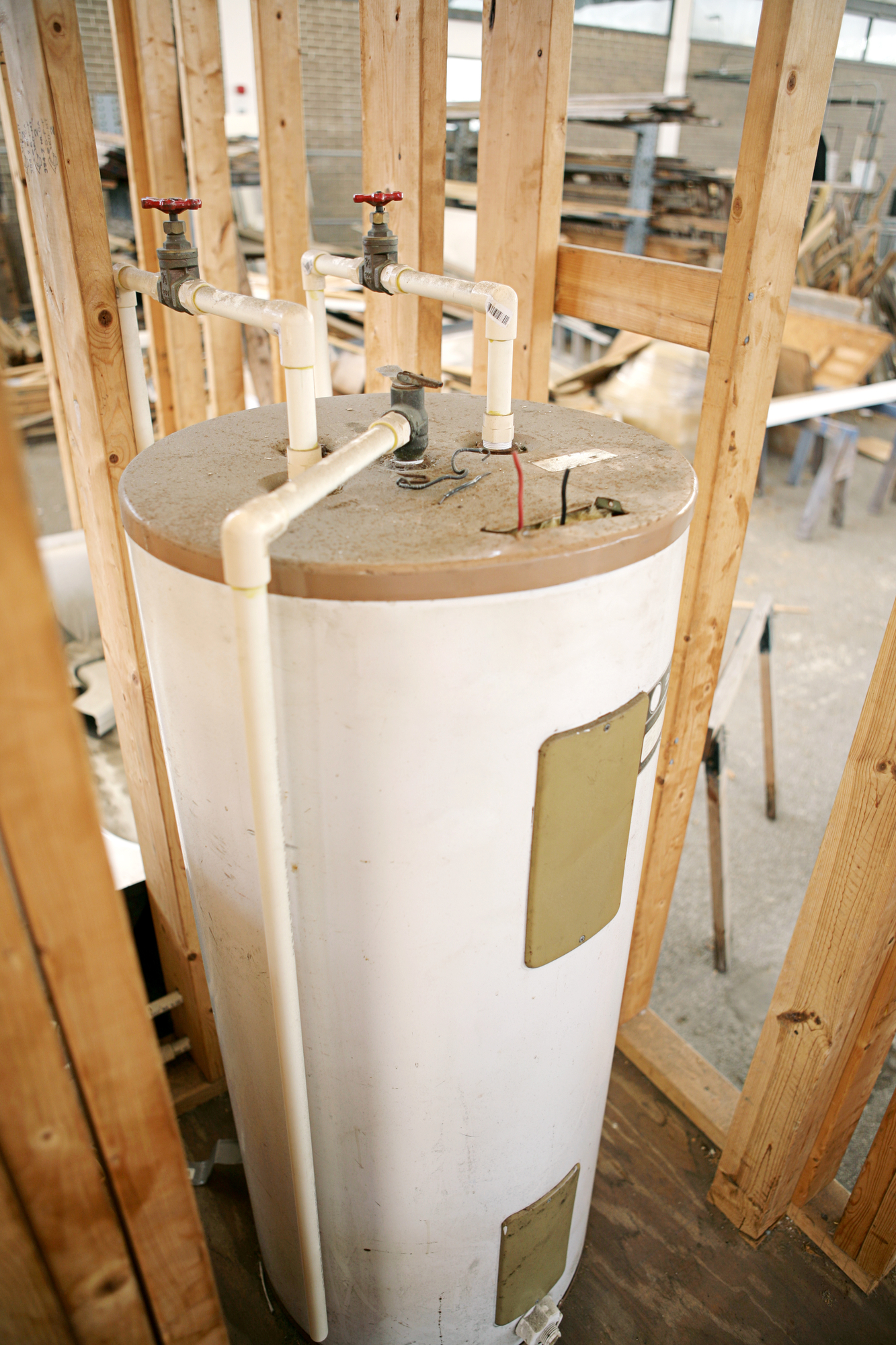 Construction site with hot water heater installed. Focus on center top of water heater.